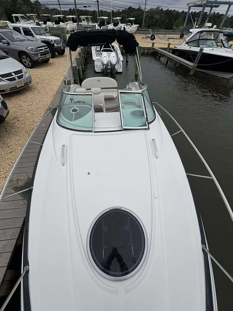 Slide: The Image of 2018 Crownline 264 CR boat docked, viewed from above, with surrounding vehicles and water. - 19