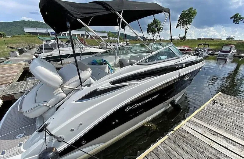 Slide: The Image of 2018 Crownline 264 CR boat docked at marina, featuring sleek design and black canopy. - 31