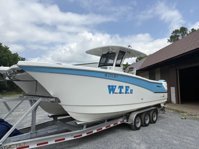 The Image of 2020 World Cat 280 CC-X boat on trailer, parked outdoors under cloudy sky. - 0