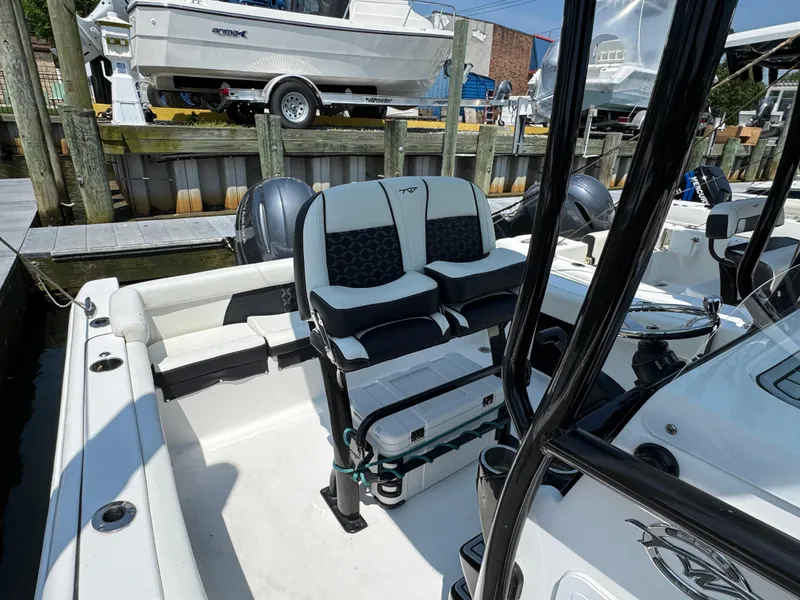 Slide: The Image of 2022 Tidewater 220 LXF boat interior with seating and console, docked at marina. - 11