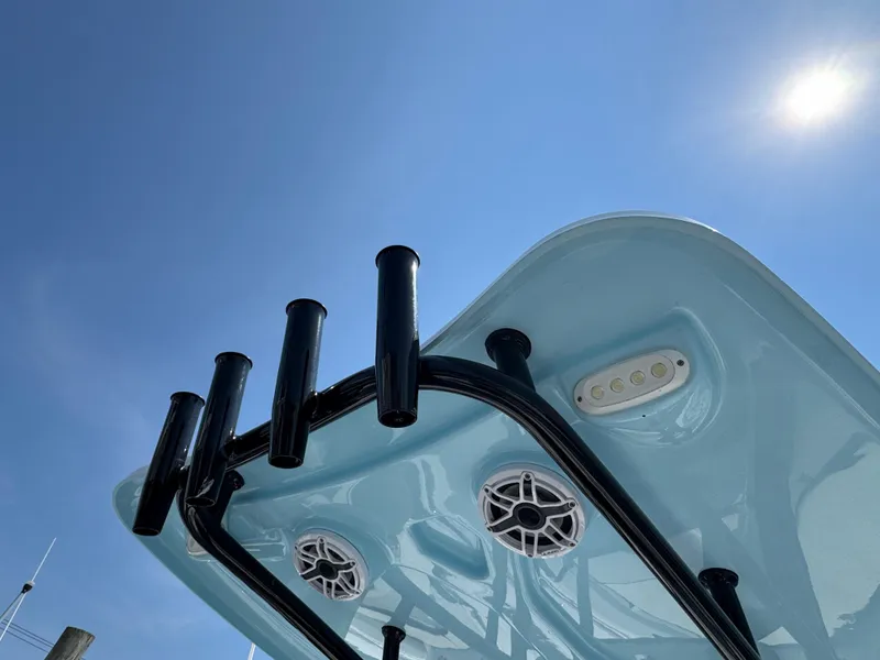 Slide: The Image of 2022 Tidewater 220 LXF boat top view with rod holders and speakers under clear sky. - 13