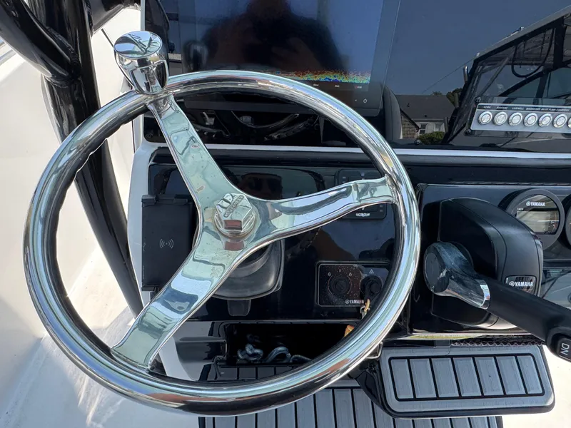 Slide: The Image of Steering wheel and controls of a 2022 Tidewater 220 LXF boat. - 16