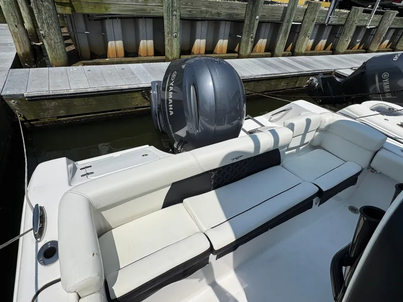 Slide: The Image of 2022 Tidewater 220 LXF boat with Yamaha engine, docked at a wooden pier. - 2