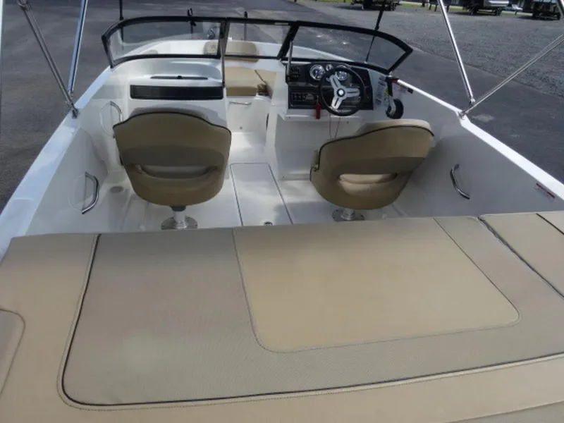 Slide: The Image of 2022 Bayliner VR4 boat interior with beige seating and steering console. - 6