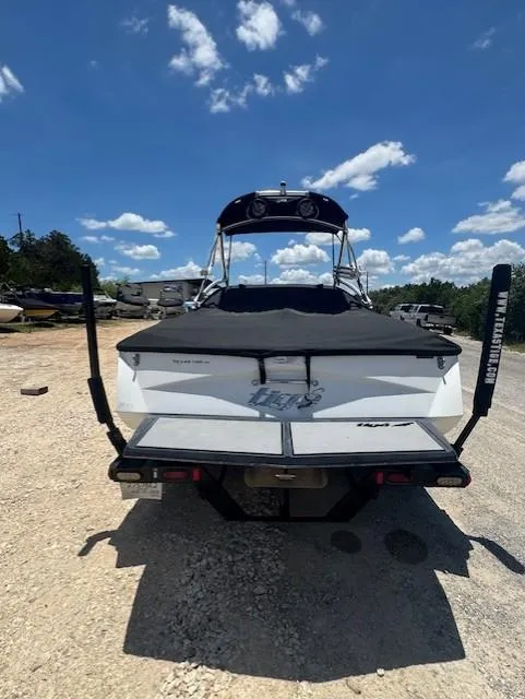 Slide: The Image of 2008 Tigé Z1 boat parked on gravel under a blue sky with clouds. - 8