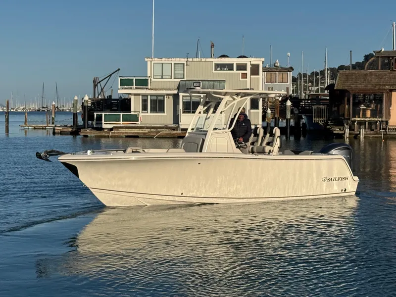 Slide: The Image of 2024 Sailfish 241 CC boat dashboard with Garmin navigation, cruising on calm waters. - 11