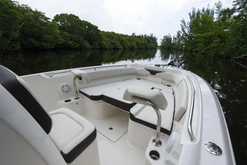 Slide: The Image of 2024 Sailfish 241 CC boat cruising on calm waters near a marina. - 3
