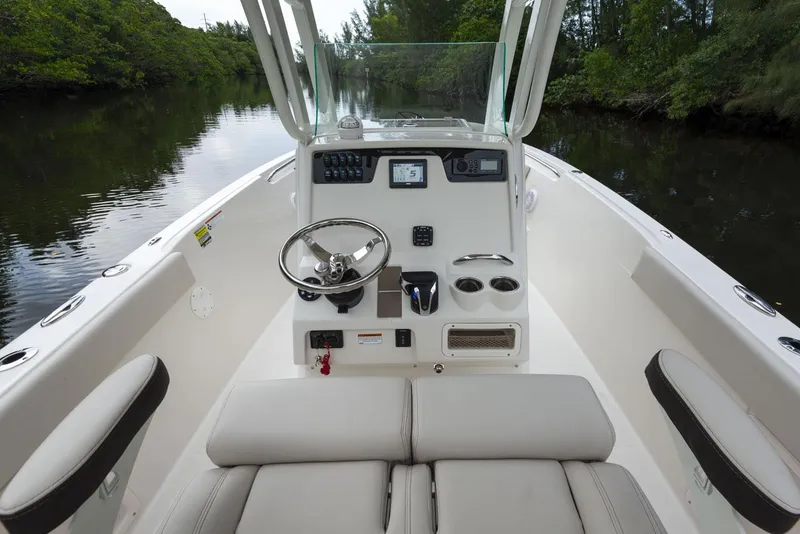 Slide: The Image of 2024 Sailfish 241 CC boat on water, sunny day, marina background. - 5
