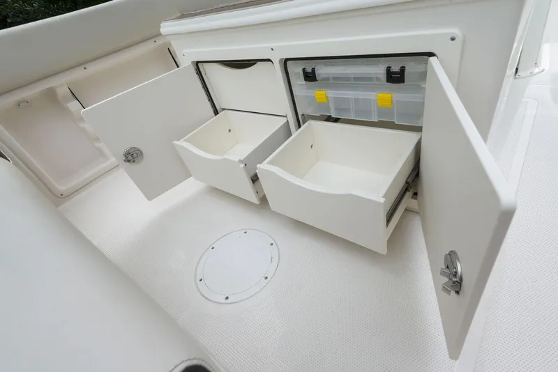 Slide: The Image of 2024 Sailfish 241 CC boat on calm water near a marina. - 9