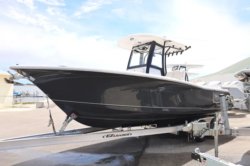Slide: The Image of 2025 Sea Hunt Ultra 265 SE boat docked near waterfront restaurant and marina. - 24