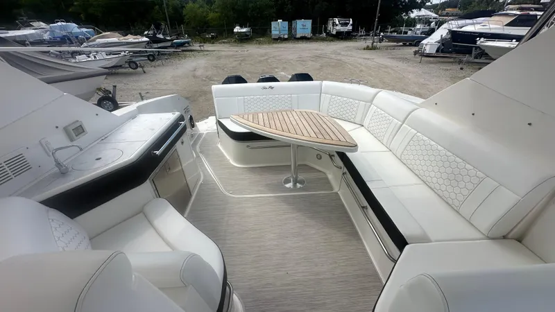Slide: The Image of 2023 Sea Ray Sundancer 320 Outboard interior with elegant seating and wooden table. - 12