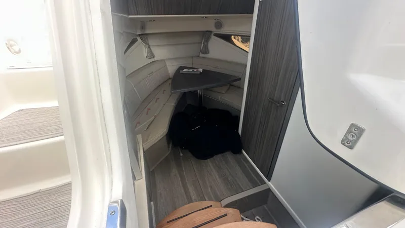 Slide: The Image of 2023 Sea Ray Sundancer 320 Outboard cabin interior with seating and table. - 7