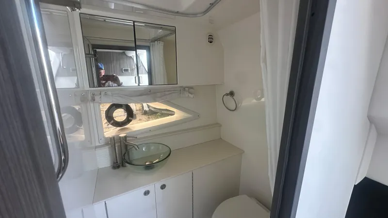 Slide: The Image of 2023 Sea Ray Sundancer 320 Outboard bathroom with modern glass sink and mirrored cabinet. - 8