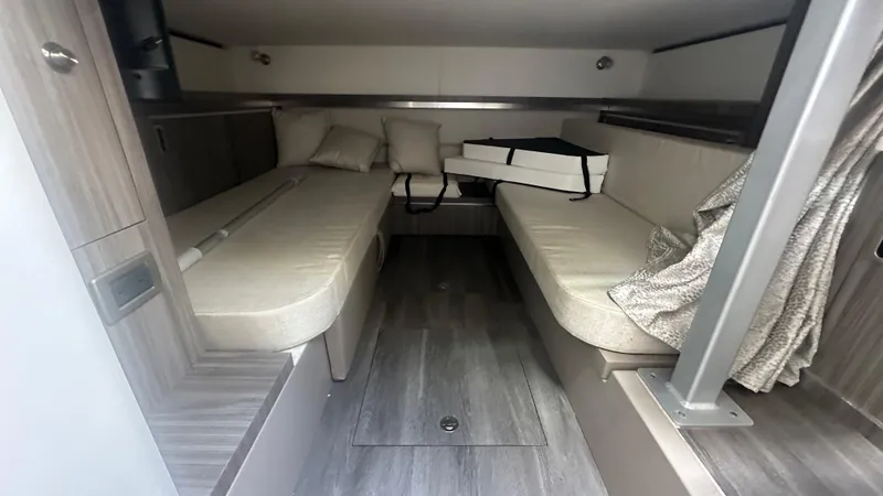 Slide: The Image of 2023 Sea Ray Sundancer 320 Outboard cabin interior with beige seating and modern design. - 9