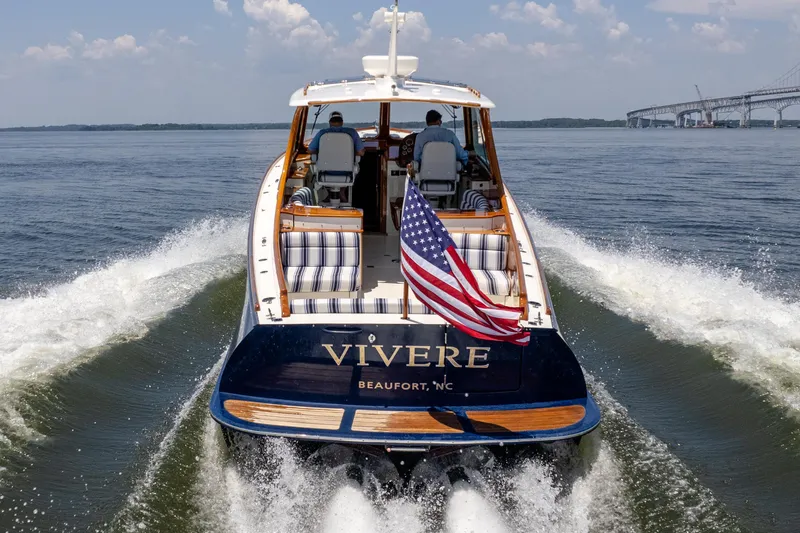 Slide: The Image of Hinckley Picnic Boat 37 MKIII cruising with American flag, 2015 model, open water backdrop. - 12
