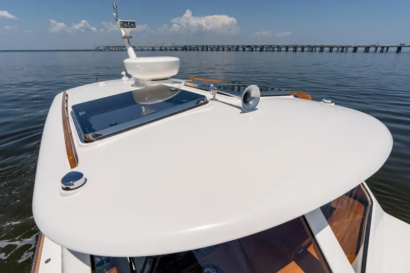 Slide: The Image of 2015 Hinckley Picnic Boat 37 MKIII cruising on calm waters near a bridge. - 14