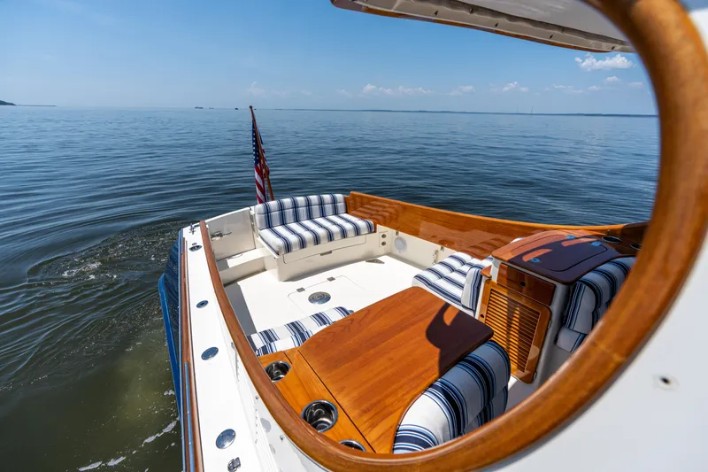 Slide: The Image of 2015 Hinckley Picnic Boat 37 MKIII on calm water, featuring elegant seating and wooden accents. - 15