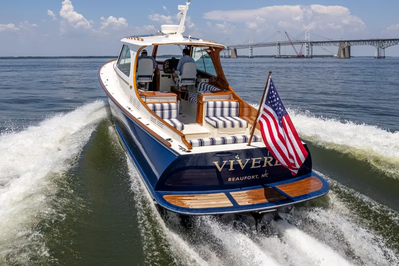 Slide: The Image of Hinckley Picnic Boat 37 MKIII cruising with American flag, bridge in background, 2015 model. - 2