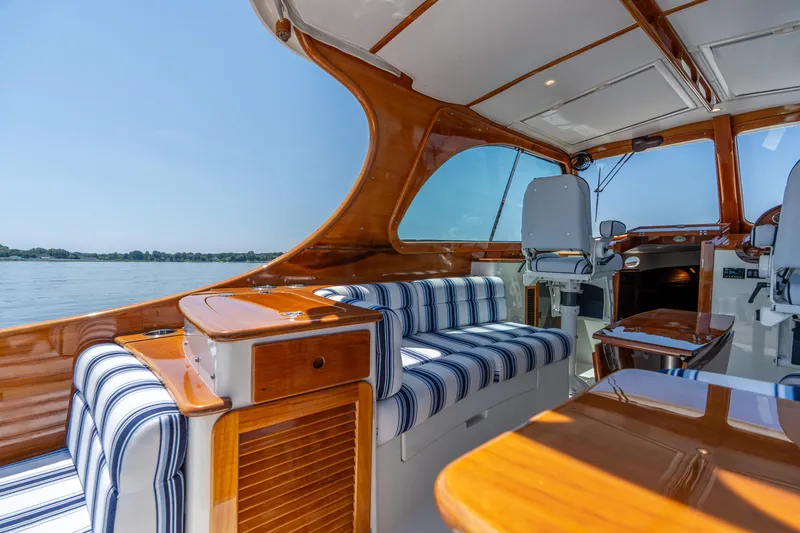 Slide: The Image of 2015 Hinckley Picnic Boat 37 MKIII interior with striped seating and polished wood finish. - 21