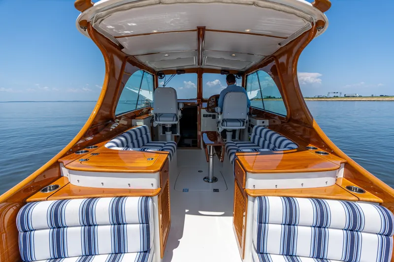 Slide: The Image of 2015 Hinckley Picnic Boat 37 MKIII interior with striped seating, cruising on calm waters. - 22