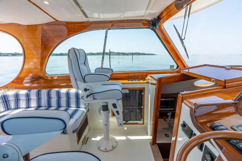 Slide: The Image of Luxurious interior of 2015 Hinckley Picnic Boat 37 MKIII with striped seating and helm. - 24