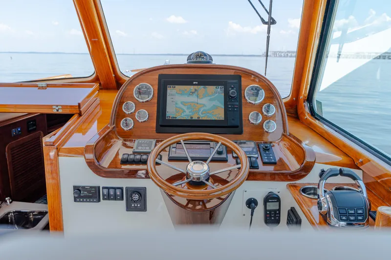 Slide: The Image of Helm of 2015 Hinckley Picnic Boat 37 MKIII with navigation display and wooden steering wheel. - 27