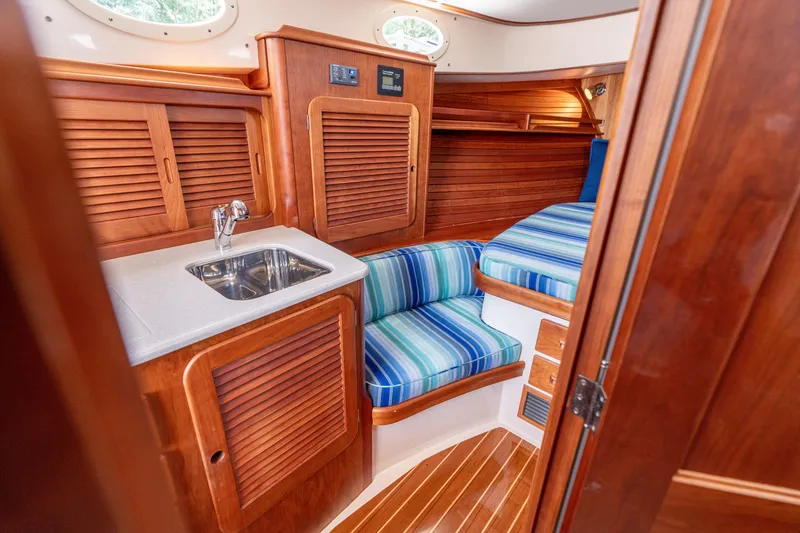 Slide: The Image of Interior of 2015 Hinckley Picnic Boat 37 MKIII with wood finish and striped seating. - 33