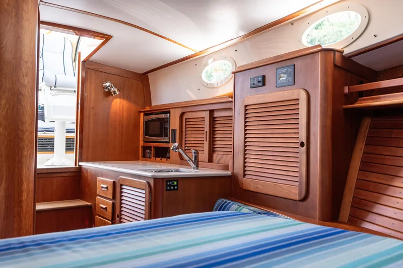 Slide: The Image of Interior of 2015 Hinckley Picnic Boat 37 MKIII with wood cabinetry and compact kitchen area. - 35