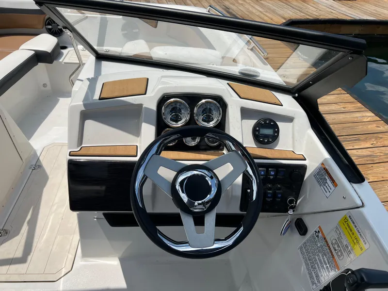 Slide: The Image of 2024 Starcraft SVX 210 IO boat dashboard with steering wheel and gauges. - 10
