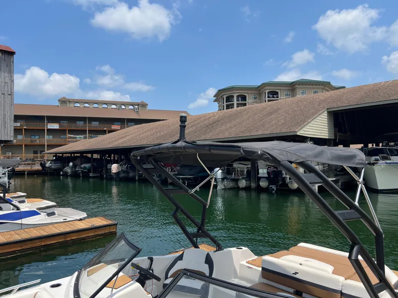 Slide: The Image of 2024 Starcraft SVX 210 IO boat docked at a marina under a clear blue sky. - 12
