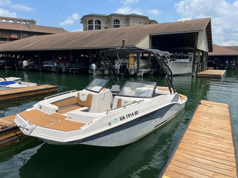Slide: The Image of 2024 Starcraft SVX 210 IO boat docked at marina with covered slips. - 13