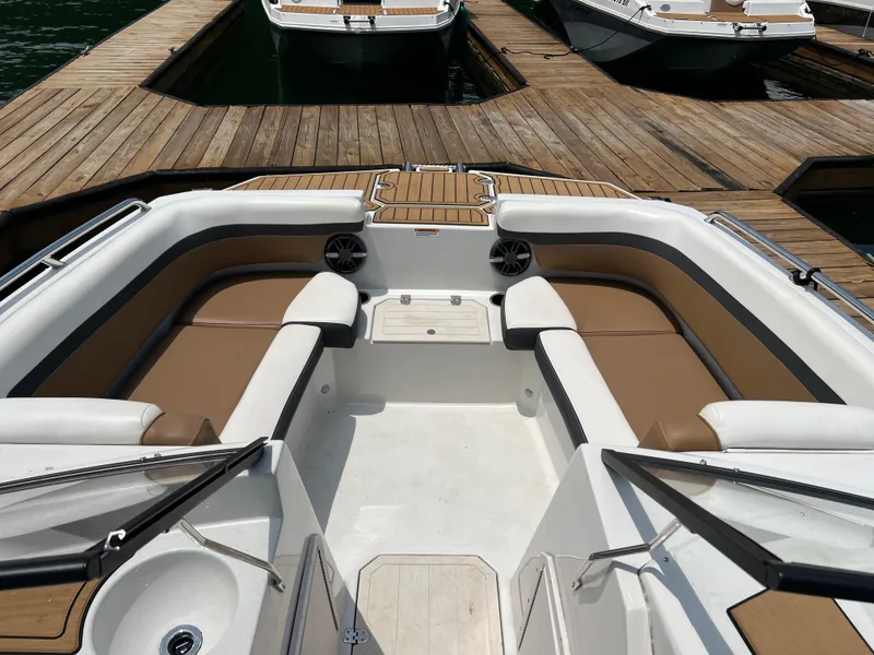 Slide: The Image of 2024 Starcraft SVX 210 IO boat interior with tan seating at dock. - 5