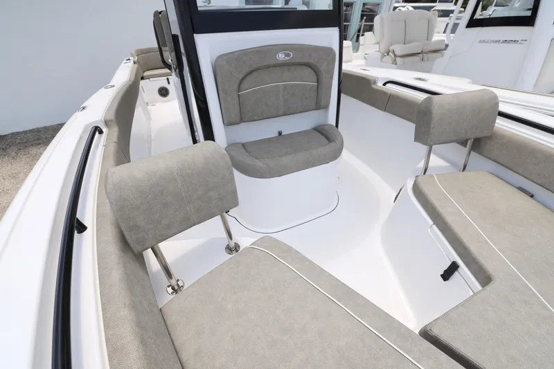 Slide: The Image of 2026 Sea Hunt Ultra 245 SE boat interior with cushioned seating and cup holders. - 24