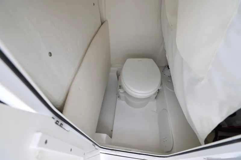 Slide: The Image of 2026 Sea Hunt Ultra 245 SE boat interior with seating and storage, dockside view. - 4