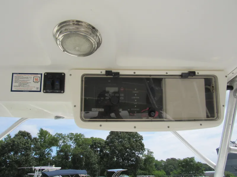 Slide: The Image of 1997 Boston Whaler 23 Conquest control panel with emergency radio instructions and switches. - 12