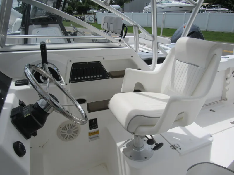 Slide: The Image of 1997 Boston Whaler 23 Conquest helm with white captain's chair and steering wheel. - 15