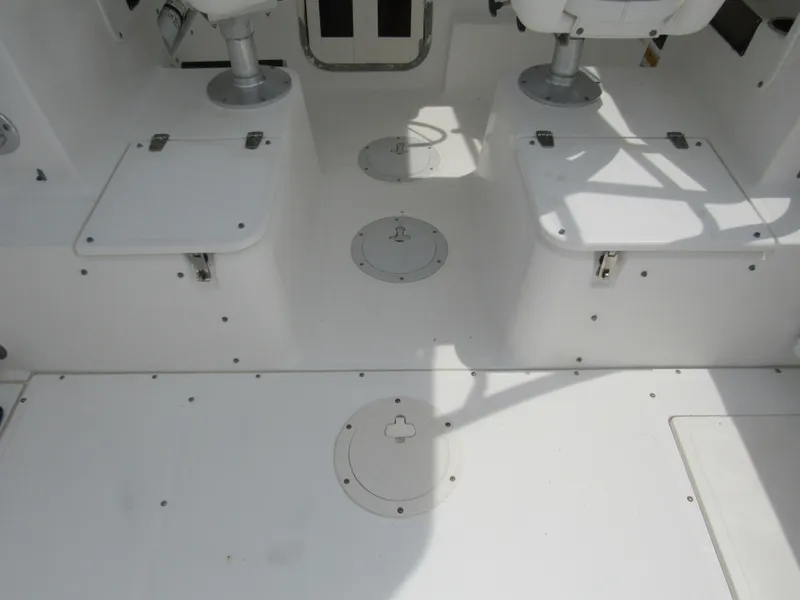 Slide: The Image of 1997 Boston Whaler 23 Conquest boat interior with white seating and storage compartments. - 25