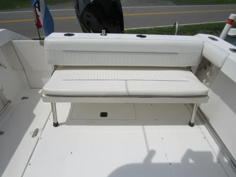 Slide: The Image of 1997 Boston Whaler 23 Conquest boat with white cushioned seating and rod holders. - 26
