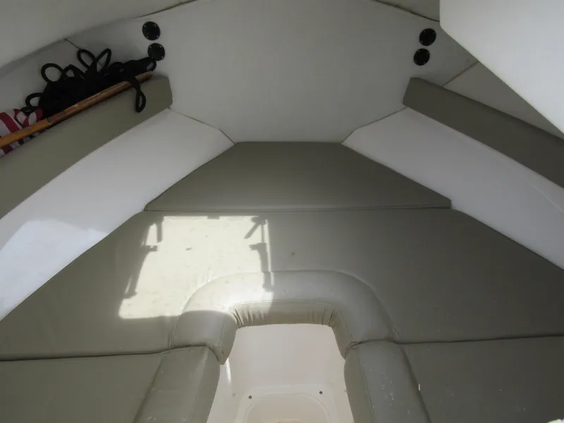 Slide: The Image of Interior cabin of a 1997 Boston Whaler 23 Conquest boat, featuring cushioned seating. - 8