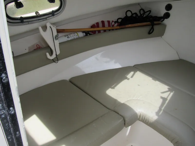 Slide: The Image of 1997 Boston Whaler 23 Conquest cabin interior with cushioned seating and storage. - 9