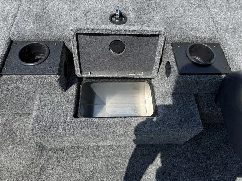 Slide: The Image of 2025 Tracker Pro Team 190 boat interior with open storage compartment and cup holders. - 13