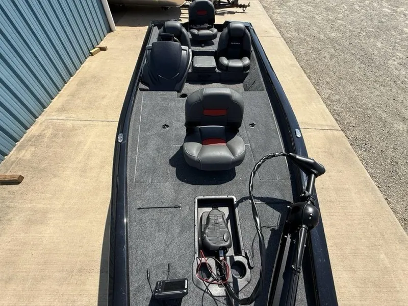 Slide: The Image of 2025 Tracker Pro Team 190 boat with seating and fishing equipment on a concrete surface. - 15