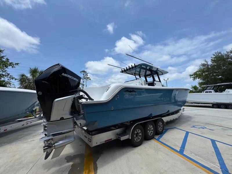 Slide: The Image of 2026 Invincible 36 Catamaran on trailer, featuring Mercury outboard engines, under a clear blue sky. - 13