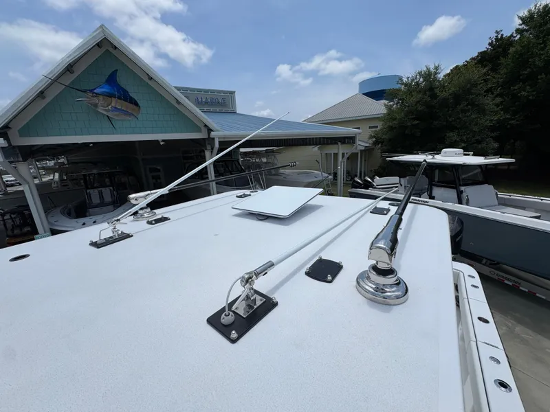 Slide: The Image of 2026 Invincible 36 Catamaran roof with antennas, docked near a marine shop. - 25