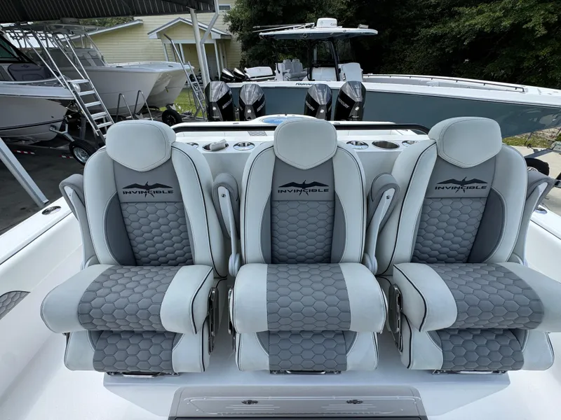 Slide: The Image of Three luxurious seats on a 2026 Invincible 36 Catamaran, featuring sleek gray upholstery. - 27