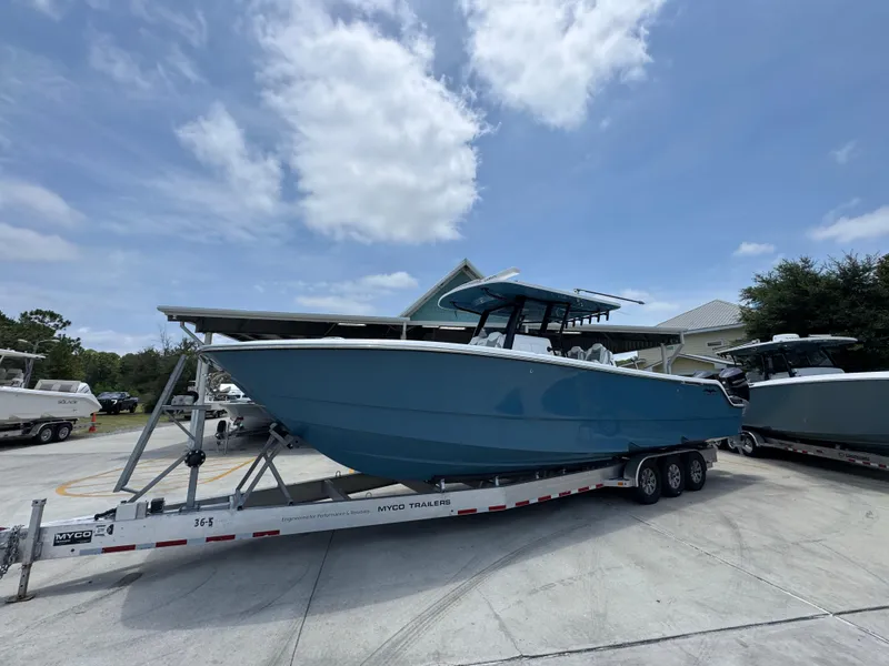 Slide: The Image of 2026 Invincible 36 Catamaran on trailer, parked outdoors under a partly cloudy sky. - 3