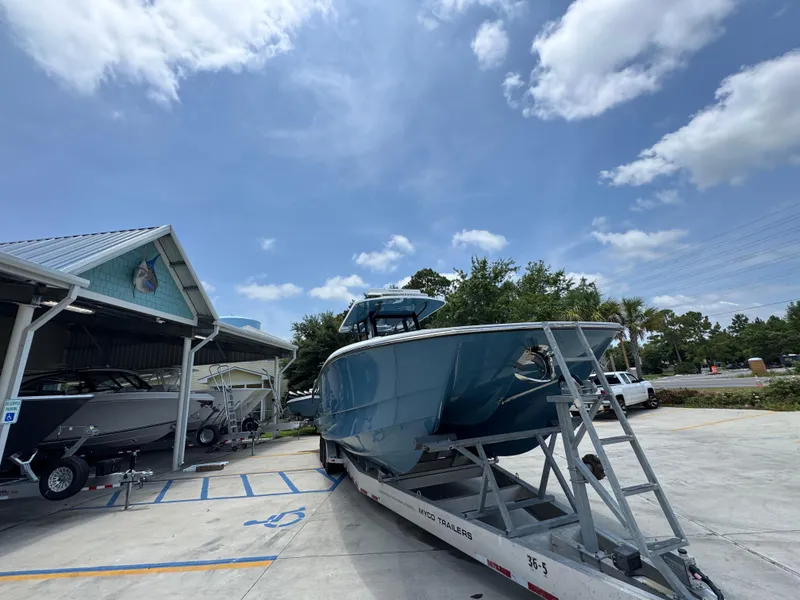 Slide: The Image of 2026 Invincible 36 Catamaran on trailer, parked outside a building under a blue sky. - 8
