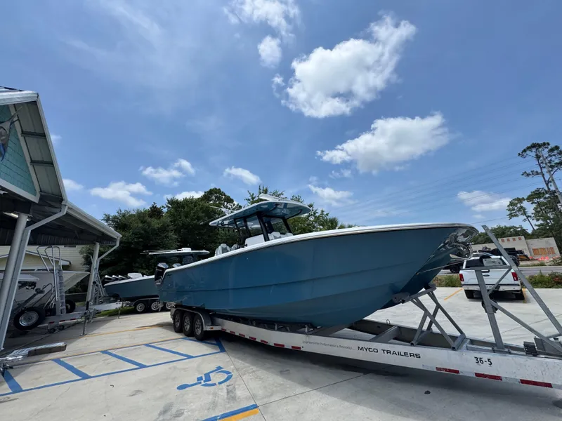 Slide: The Image of 2026 Invincible 36 Catamaran on trailer under clear blue sky. - 9