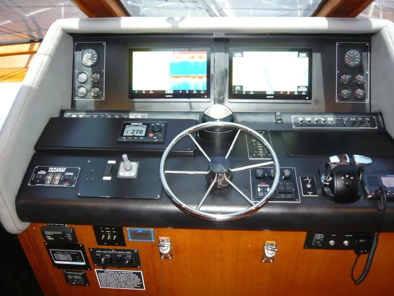 Slide: The Image of Cockpit of 1990 Viking Motor Yacht with steering wheel, navigation screens, and control panels. - 18