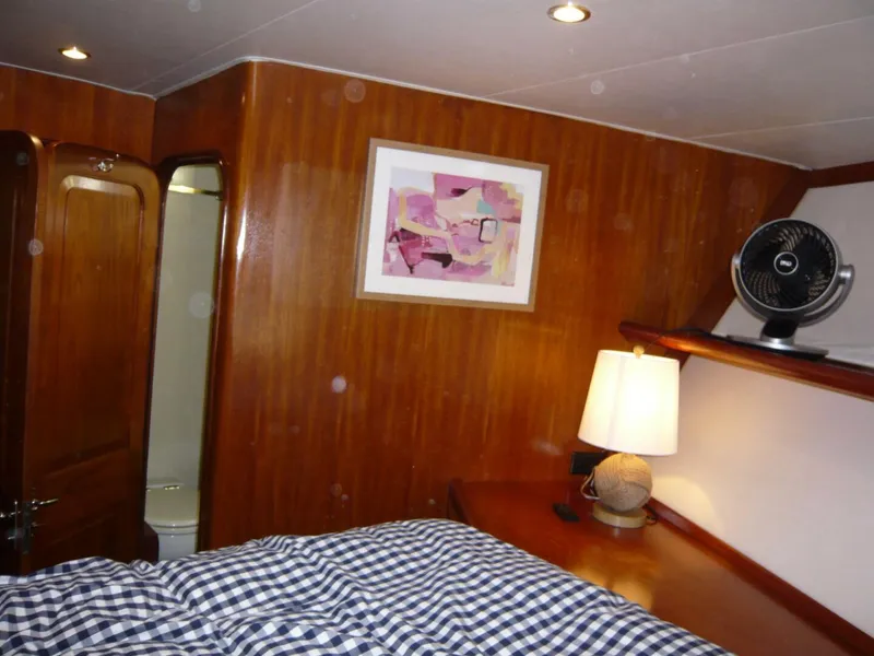 Slide: The Image of Cozy cabin interior of 1990 Viking Cockpit Motor Yacht with wood paneling and modern decor. - 21